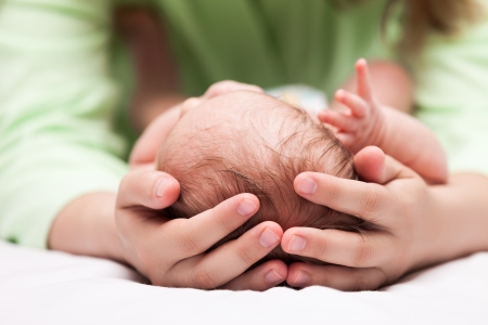 Loving mother hand holding cute sleeping newborn baby childの写真素材