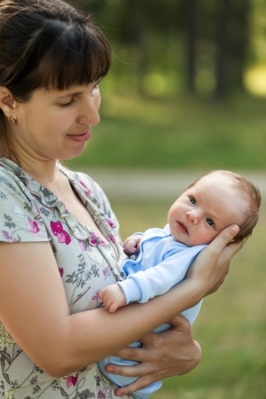 Loving mother hand holding cute little newborn baby child walking outdoorの写真素材