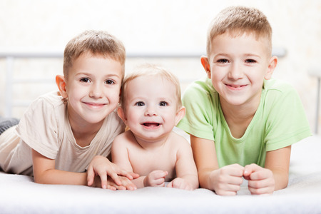 Family happiness - three little smiling child boy brothersの写真素材
