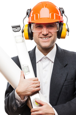 Businessman in black suit and safety hardhat helmet hand holding paper drawings plan and engineer tools white isolatedの写真素材