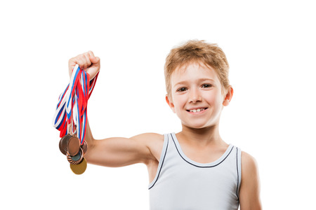 Sport success and win concept - smiling athlete champion child boy hand holding first place victory gold medal awardの写真素材