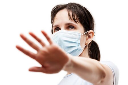 Human population virus, infection, flu disease prevention and industrial exhaust emissions protection concept - beauty woman wearing respiratory protective medical mask hand hiding face white isolatedの写真素材
