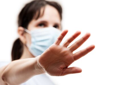 Human population virus, infection, flu disease prevention and industrial exhaust emissions protection concept - beauty woman wearing respiratory protective medical mask hand hiding face white isolatedの写真素材