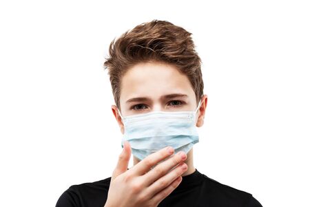 Human population virus, infection, flu disease prevention and industrial exhaust emissions protection concept - teenager boy wearing respiratory protective medical mask hand hiding face white isolatedの写真素材