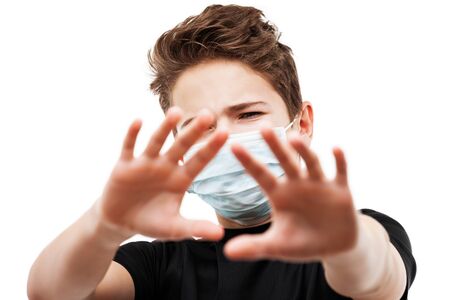 Human population virus, infection, flu disease prevention and industrial exhaust emissions protection concept - teenager boy wearing respiratory protective medical mask hand hiding face white isolatedの写真素材