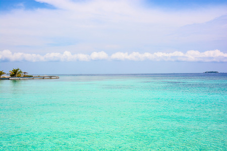 atoll of the tropics and maldives that are reflected in a sea of emerald with a cobalt blue skyの写真素材
