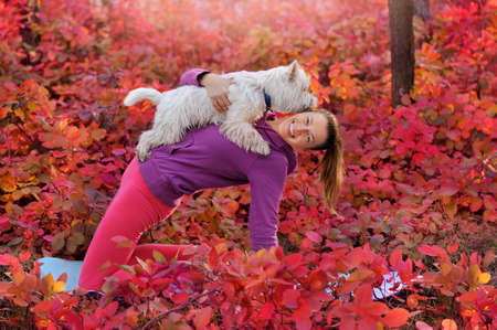 Sportive woman making yoga bridge pose with her dogの写真素材