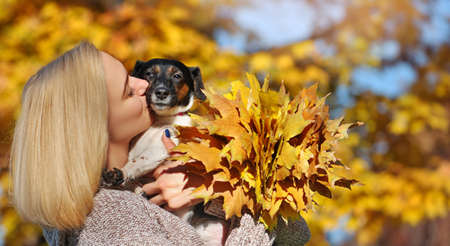 Close-up portrait of a blonde woman kissing her little jack russel terrierの写真素材