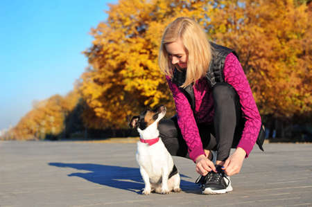 Woman with her jack russel dog at the fitness training breakの写真素材