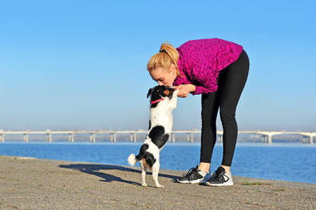 Woman kissing her jack russel terrier dog after joggingの写真素材
