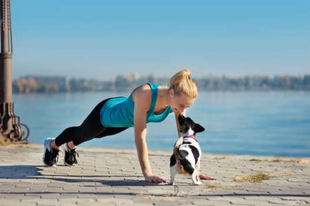 Woman kissing her dog while push ups exercisesの写真素材