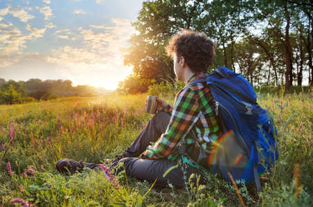 Young hiker having rest at the sundownの写真素材