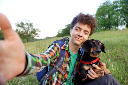 Young boy wit his dachshund dog making selfie