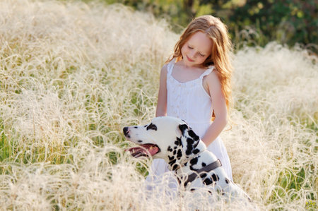 Close-up portrait of a girl taking care of her dalmatian dog