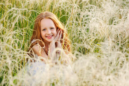 Pretty smiling girl in the field of feather grassの写真素材