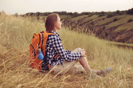 Female backpacker having rest the rural valleyの写真素材