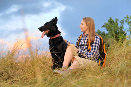 Woman with her dog against sky backgroundの写真素材