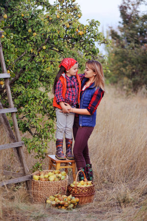 Full length picture of mother and daughter under the pear treeの写真素材