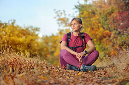 Sportive woman sitting on the path at the forestの写真素材