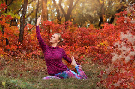 Sportive woman practicing pigeon yoga pose at the autumn trainingの写真素材