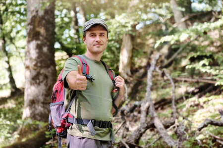 Happy hiker showing thumbs up having gesture journey in the forestの写真素材