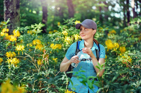 Girl traveler opening her bottle of waterの写真素材