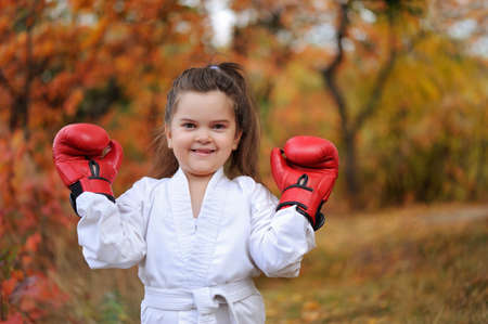 Little girl wearing kimono showing boxing glovesの写真素材