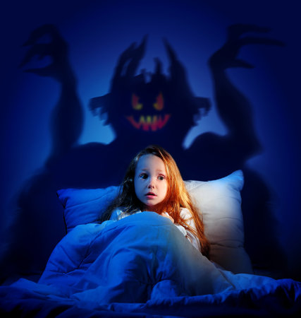 Little girl scared of  night monster shadowの写真素材