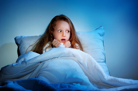 Scared girl staying sleepless in her bedの写真素材