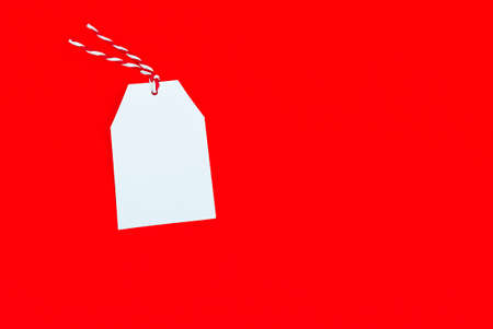 white tag on bright red background close upの写真素材