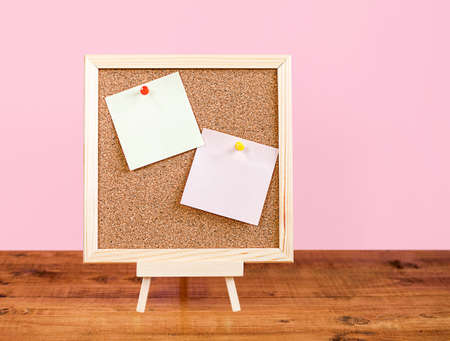 visual board with blank sticky notes on wooden table and pink backgroundの写真素材