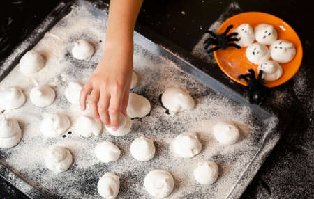 the child's hand reaches for the baking sheet. halloween conceptの写真素材