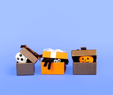 gift boxes with halloween symbols on purple background close-upの写真素材