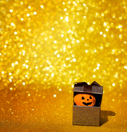 box with peeking pumpkin on glitter backgroundの写真素材