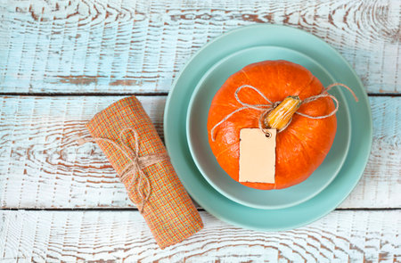 plate with pumpkin and napkin on blue wooden tableの写真素材
