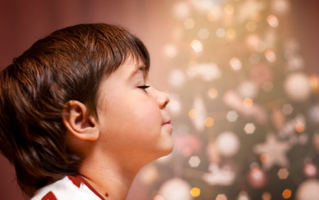 portrait of a child in profile against the background of Christmas treesの写真素材