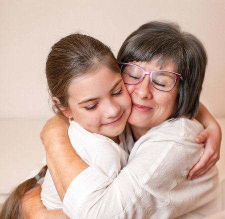 grandmother hugging her granddaughter close-upの写真素材