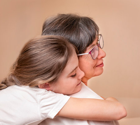 girl hugging an adult woman from the back close-upの写真素材