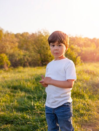 a child stands outdoors in the rays of the setting sun