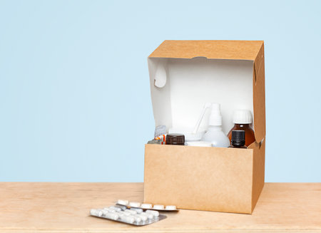 open cardboard box with medicines on the table close-up on a blue backgroundの写真素材