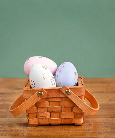 Easter eggs in a wicker basket close-up on a green background