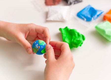 A child sculpts a globe from plasticine.の写真素材