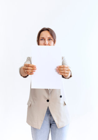 Young woman holding blank sheet of paper isolated on gray backgroundの写真素材