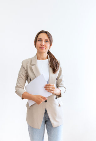 Portrait of a confident businesswoman holding documents isolated on gray backgroundの写真素材