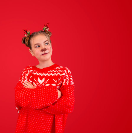girl in the image of a Christmas deer on a red background with copy spaceの写真素材