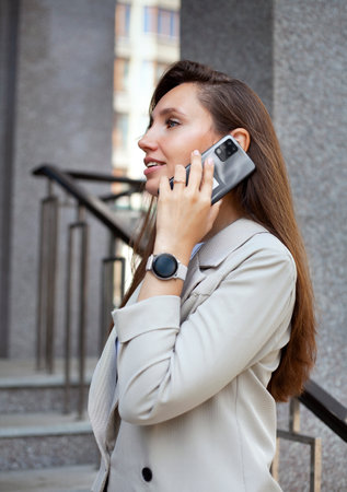 Close up portrait of a young businesswoman talking on mobile phone outdoorsの写真素材