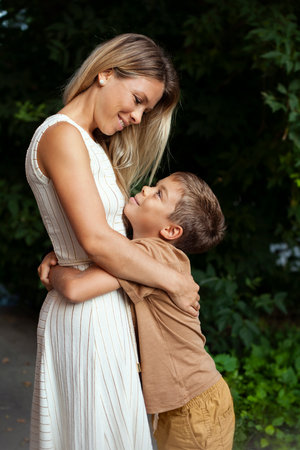 Portrait of mother and son embracing each other in the park.