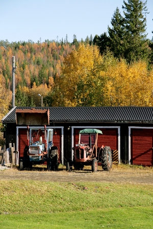 Two old tractors by a garageのeditorial素材
