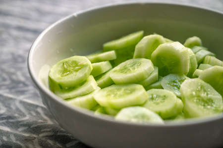 Bowl of pickled cucumber isolated on white backgroundの写真素材