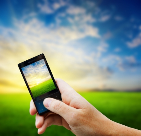 cell phone in hand and country sunset cell phone in hand and country sunset